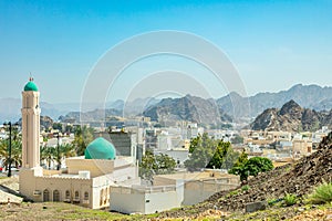 Muscat Takia historical city center streets overview panorama with green mosque some and rocks in the background, Oman