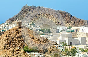 Muscat Takia historical city center streets overview panorama with rocks and medieval tower in the background, Oman