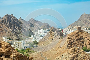 Muscat Takia historical city center streets overview panorama with rocks and medieval tower in the background, Oman