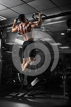 Muscle athlete man in gym making elevations