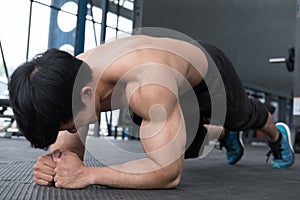 Muscle man doing plank position in gym. bodybuilder male working