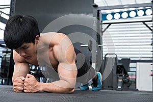 Muscle man doing plank position in gym. bodybuilder male working