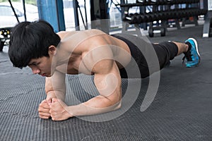 Muscle man doing plank position in gym. bodybuilder male working