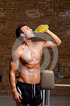 Muscle man at gym relaxed with energy drink