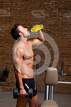 Muscle man at gym relaxed with energy drink