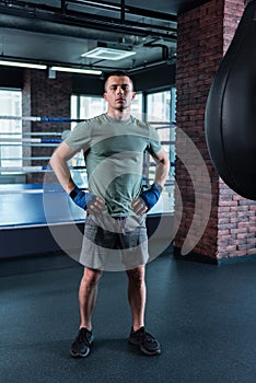 Muscle man standing in modern gym while training hard