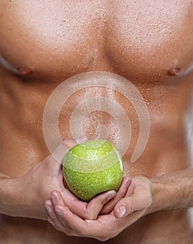 Muscle wet naked young man torso and apple