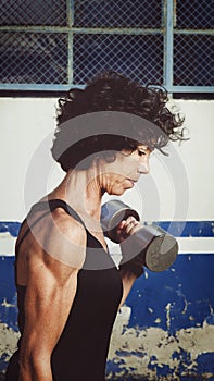 Muscled adult woman exercising in the street