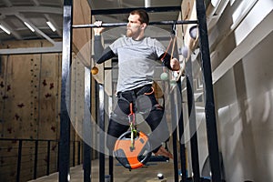 Muscled sportsman with physical disability performing pull ups with load