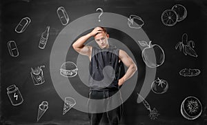 Muscled young man pondering on what to choose: junk or healthy food