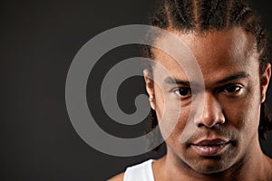 Muscular African American, portrait on a black background of an athletic black guy with dreadlocks on his head