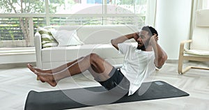 Muscular African man in activewear doing abdominals sit up exercises