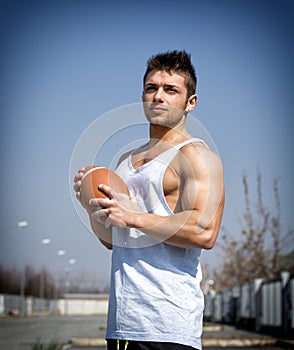 Muscular american football with ball in hand.