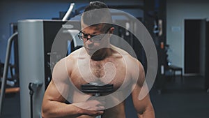 Muscular arab man training with dumbbells in the gym.