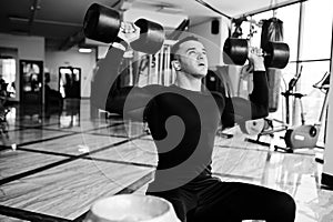 Muscular arab man training with dumbbells in modern gym