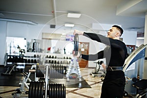 Muscular arab man training with dumbbells in modern gym