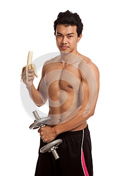 Muscular Asian man with banana and dumbbell