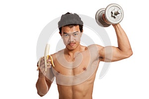 Muscular Asian man with banana and dumbbell
