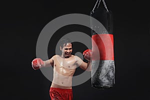 Muscular asian man boxer training with punching bag