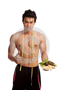 Muscular Asian man diet with clean food and measuring tape