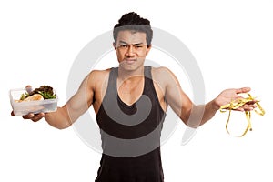 Muscular Asian man diet with measuring tape and clean food