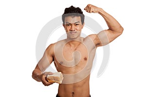 Muscular Asian man load carbs with some bread flexing biceps