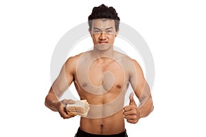 Muscular Asian man thumbs up load carbs with some bread
