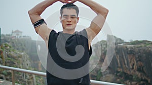 Muscular athlete doing sport exercise in urban park. Handsome man stretching