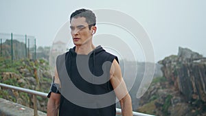 Muscular athlete doing sport exercise in urban park. Handsome man stretching