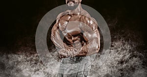 Muscular athlete posing in the studio. Fitness and classic bodybuilding concept