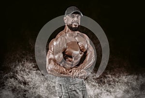 Muscular athlete posing in the studio. Fitness and classic bodybuilding concept