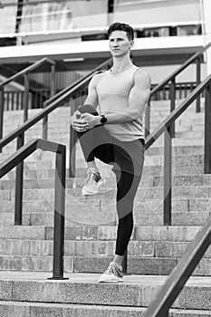 Muscular athlete warming up joints before morning jog