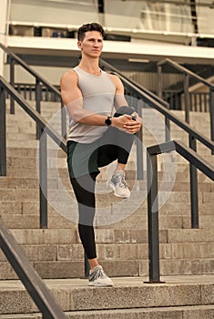 Muscular athlete warming up joints before morning jog