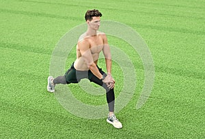 Muscular athlete warming up before workout outdoors, sport concept