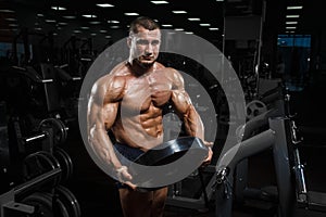 Muscular athletic bodybuilder fitness model posing after exercises