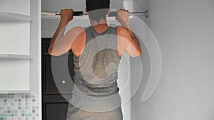 Muscular Athletic Fit Man is Engaged in Hard Fitness at Home. Young Guy Does a Pull-up Exercise