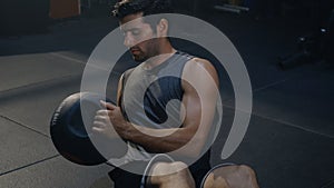 Muscular athletic man doing training abdomen exercises working out with a medicine ball