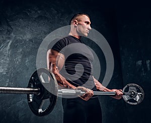 Muscular attractive bodybuilder lifting a barbell