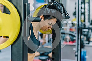 Muscular attractive young woman doing workout in the gym, lifting weights with barbell on shoulders. Hard workout for cross fit.