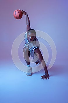 Muscular basketball player with ball shows skill
