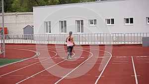 Muscular and beautiful girl doing exercises. Athletics girl, stadium