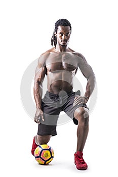 Muscular black man exercising with soccer ball