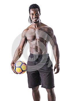 Muscular black man exercising with soccer ball