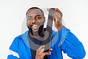 Muscular black young man exercising with elastic bands in studio, isolated on white.