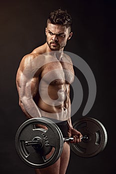 Muscular bodybuilder guy doing exercises with big dumbbell