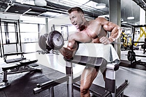 Muscular bodybuilder guy doing exercises with dumbbell