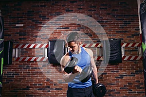 Muscular bodybuilder guy doing exercises with dumbbells