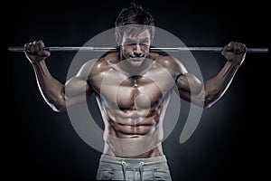 Muscular bodybuilder guy doing exercises with dumbbells