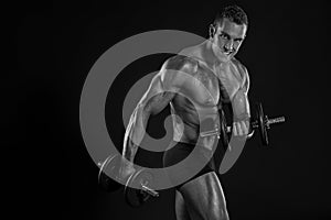 Muscular bodybuilder guy doing exercises with dumbbells