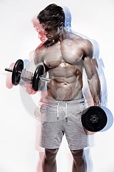 Muscular bodybuilder guy doing exercises with dumbbells